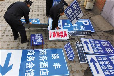 2009年12月8日,北京相關(guān)部門在整治行動中,拆除“山寨指路牌”。圖/視覺中國