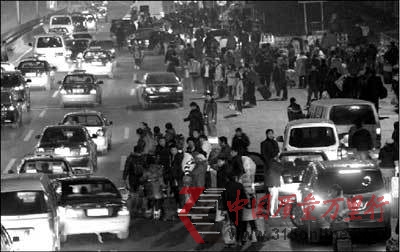 1月30日深夜,旅客在西站北廣場(chǎng)邊走邊打車。 本報(bào)實(shí)習(xí)記者 趙恩澤 攝 1月30日深夜,旅客在西站北廣場(chǎng)邊走邊打車。 本報(bào)實(shí)習(xí)記者 趙恩澤 攝