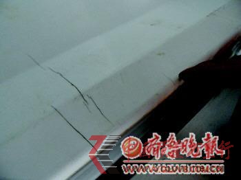 趙先生指著約2厘米的裂痕說:“這是購買半年后出現的,現在又多了四條”。 本報記者 任洪忠 攝 趙先生指著約2厘米的裂痕說:“這是購買半年后出現的,現在又多了四條”。 本報記者 任洪忠 攝